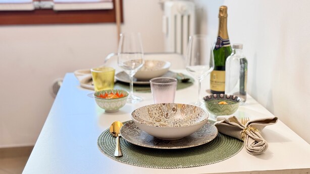 A dining table set with various dishes, glasses, and a bottle of champagne. - Casa Dora in Chioggia (Chioggia)