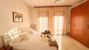 A bedroom with a bed, a bedside table with a clock, a framed picture on the wall, and a wardrobe. - Casa Dora in Chioggia (Chioggia)