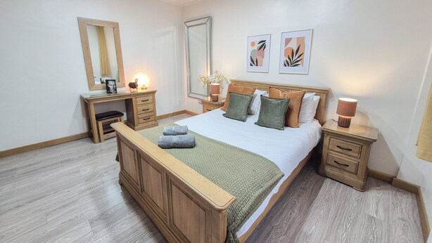 A bedroom with a wooden bed, bedside tables, a desk, and a mirror. - Cosy 4-Bed, 2-Bath flat with AC near Hyde Park , Paddington , Marylebone (London)