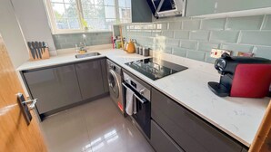 A modern kitchen with a built-in oven, microwave, and dishwasher. - Cosy 4-Bed, 2-Bath flat with AC near Hyde Park , Paddington , Marylebone (London)