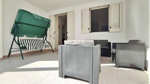 A sunlit room with a green outdoor umbrella, a striped bench, and two wicker sofas. - Casa Golden - A Due Passi Dalle Spiagge Di Pescoluse (Salve)