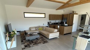 A spacious living area with a sofa, coffee table, and a kitchen in the background. - 🌿 Villa with swimming pool and panoramic view Auriol Near Cassis, Marseille and Aix (Auriol)