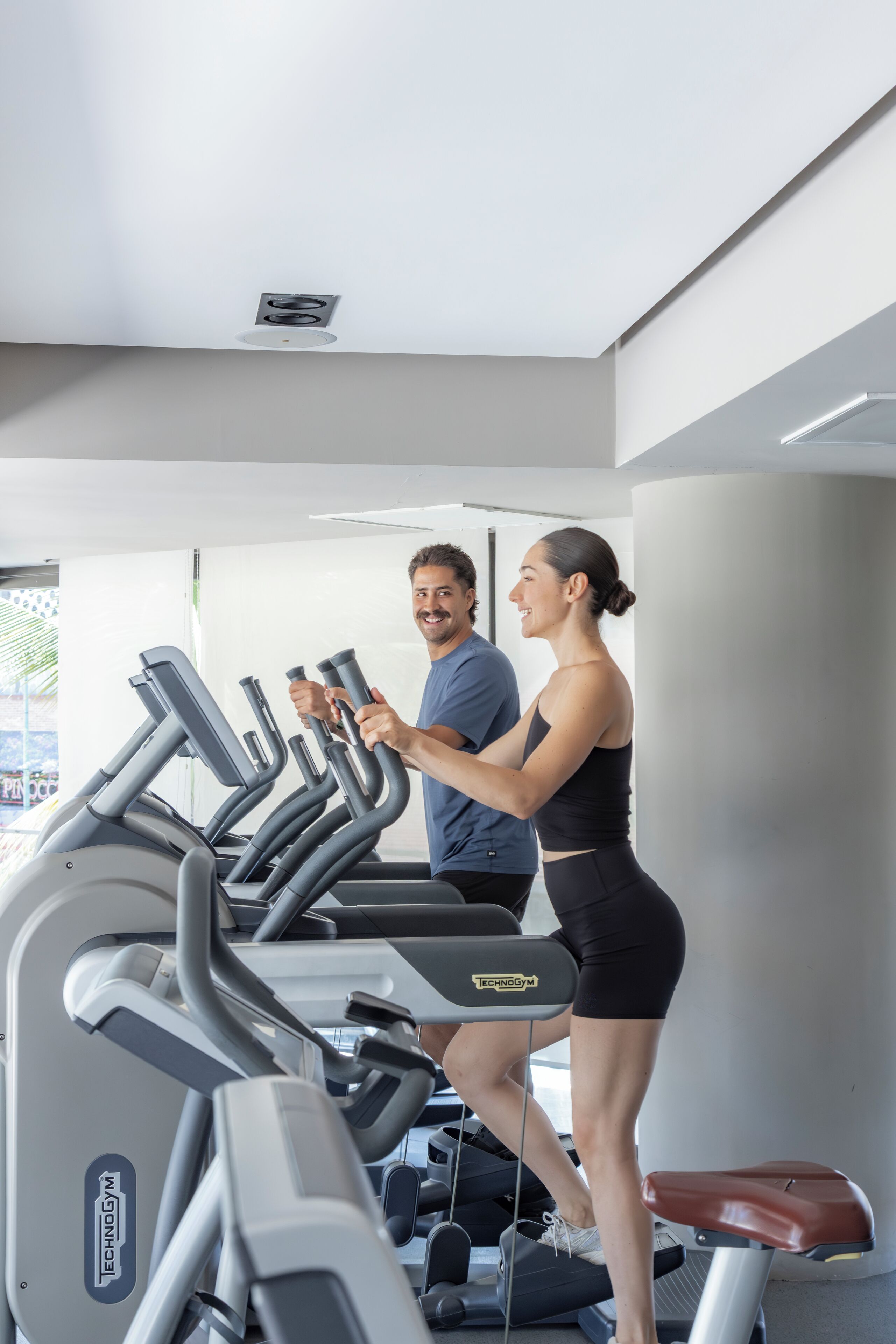 A gym with treadmills and a person using one.