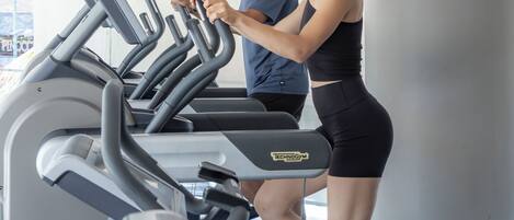 A gym with treadmills and a person using one.