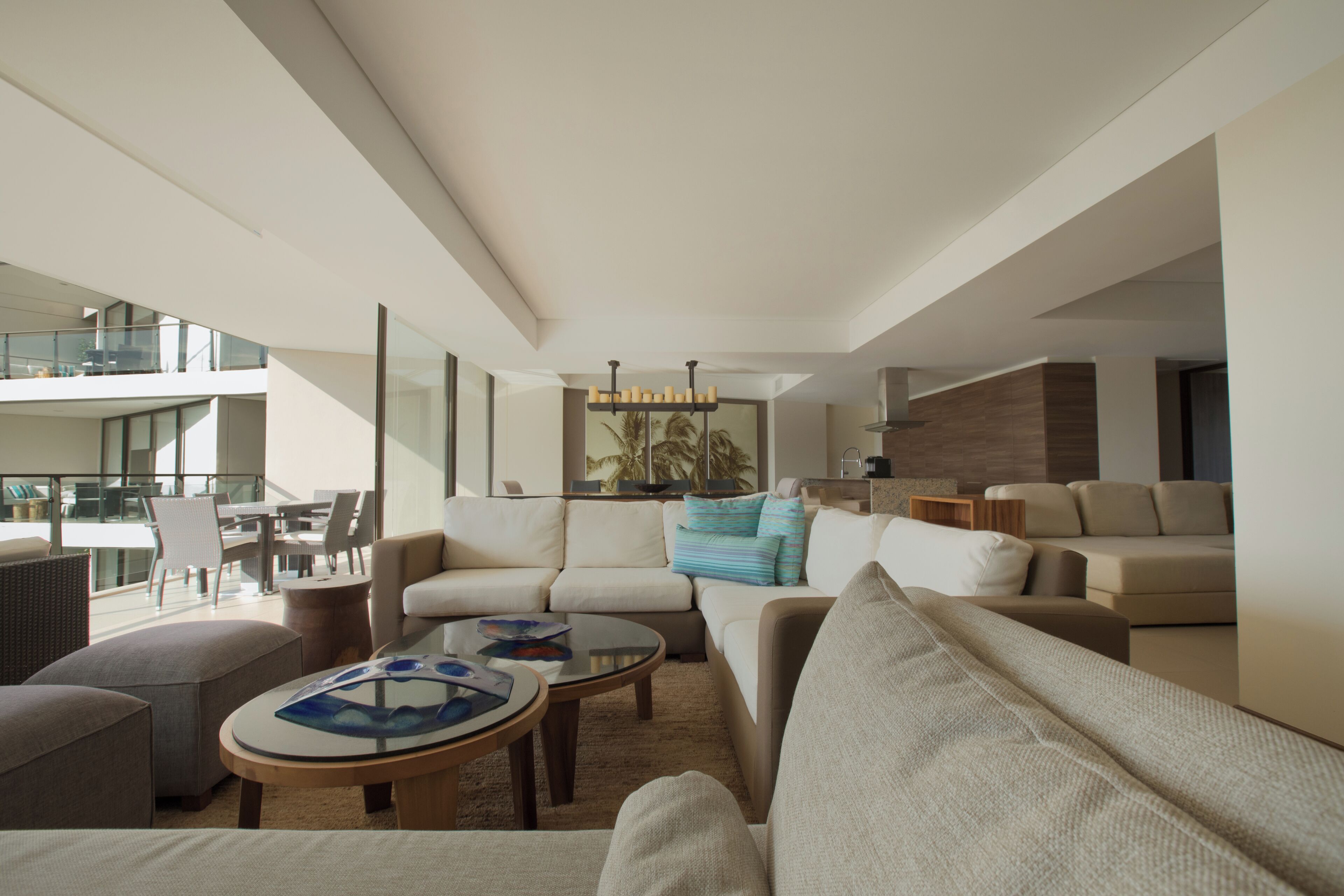A modern living room with a sofa set, a coffee table, and a dining area with chairs.