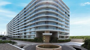 A modern hotel with a curved facade, multiple balconies, and a central courtyard with a fountain. - Live Aqua Private Residences Vallarta (Puerto Vallarta)