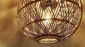 A dining area with a long table, chairs, and a decorative hanging light fixture. - À Villa di Rutali (Rutali)