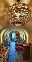 Comedor con una mesa larga, sillas y una lámpara colgante decorativa.