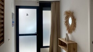 A hotel room with a sliding door, a mirror, and a wooden shelf. - A (VA079-4) TH Bioparc con Terraza Apartment D (Valencia / València)