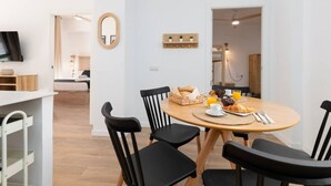 A modern dining area with a round table, black chairs, and breakfast items. - A (VA080-5) TH Bioparc con Terraza Apartment E (Valencia / València)