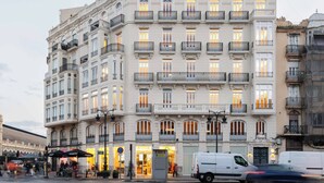 Un immeuble à plusieurs étages, doté de balcons décoratifs et de grandes fenêtres.