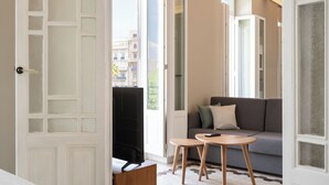 Un salon moderne avec un canapé, une petite table en bois et un téléviseur.