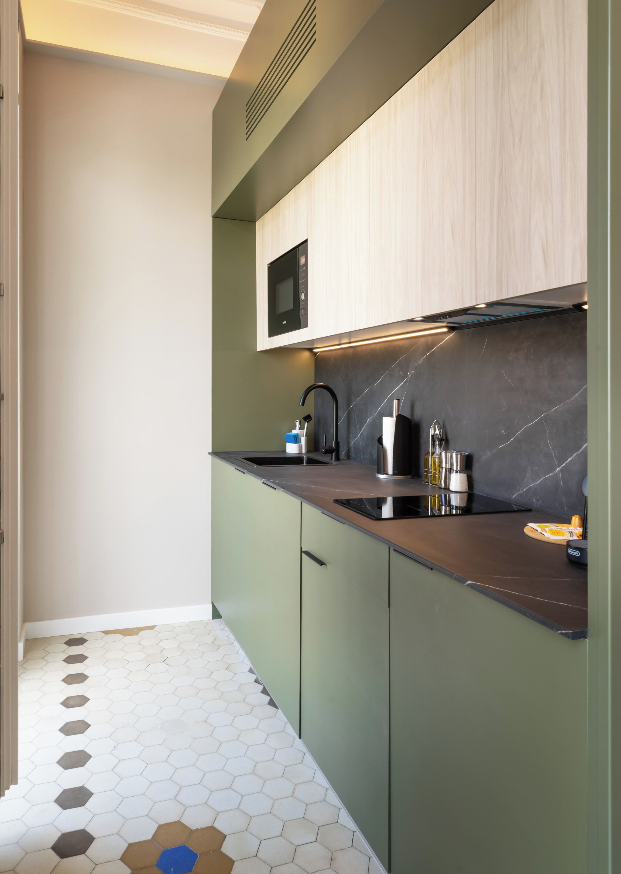 A modern kitchen with a microwave, sink, and stainless steel appliances.