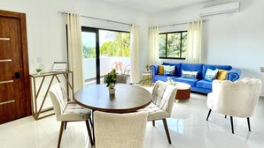 A modern living room with a round dining table, two sofas, and a coffee table.