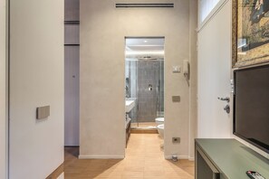 Een moderne badkamer met een douchecabine van glas, een toilet en een wastafel.