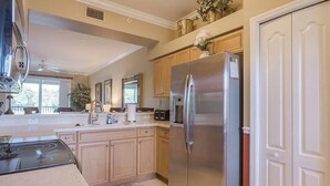 Eine moderne Küche mit Edelstahlgeräten, Holzschränken und einem großen Kühlschrank.