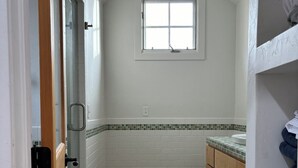 Een kleine badkamer met douche, toilet en wastafel.