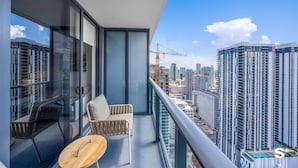 Ein Balkon mit Blick auf eine Stadtlandschaft, darunter Hochhäuser und ein Baukran.