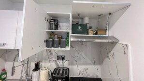 A compact kitchen with a built-in microwave, a toaster, and a coffee maker. - Sleek studio flat near King’s Cross, St Pancras, Euston with Free Wi-Fi (London)