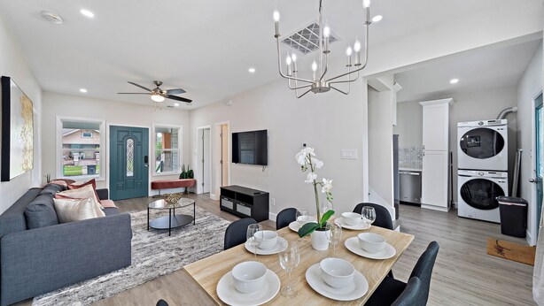 A modern living room with a sofa, dining table set for four, and a kitchen area with appliances. - Modern Chic Retreat in the Heart of EaDo, Houston (Houston)