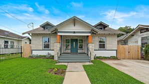 A two-story house with a front porch, a driveway, and a well-maintained lawn. - Modern Chic Retreat in the Heart of EaDo, Houston (Houston)