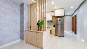 Une cuisine moderne dotée d’un îlot central en bois, d’appareils électroménagers en acier inoxydable et d’un dosseret en marbre.