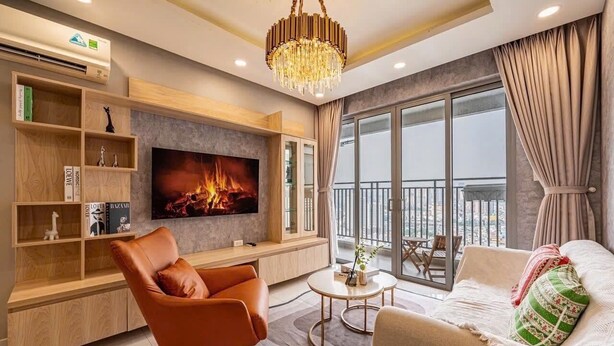 A modern living room with a TV, wooden shelves, a leather chair, a round coffee table, and a balcony with a view.
