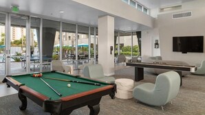 A pool table and billiards in a modern indoor setting with large windows and a view of the outdoors. - 2 Bedroom 2 Bath Condo in Oceanside Within Walking Distance to Ocean and Dining (Oceanside)