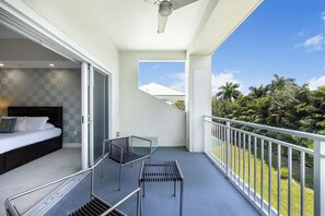 A balcony with a bed, a chair, and a table. - Two-Level Town House-Doral location-We Host (Miami)