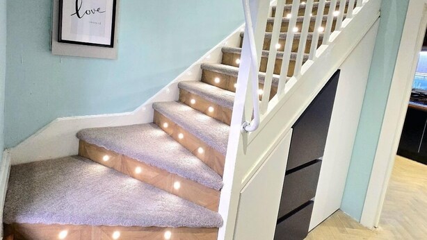 A staircase with a white railing, carpeted steps, and wall-mounted picture frames. - Quirky 2-Bed with Free Parking (Paisley)