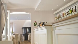 Una habitación de hotel moderna con suelo de madera, una chimenea blanca y una estantería con varias botellas.