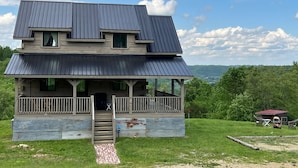 A two-story cabin with a porch, a covered front porch area, and a view of the surrounding landscape. - Driftless Log Cabin w/ Kickapoo Valley View (Readstown)