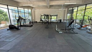 A gym with various exercise equipment, large windows, and a tiled floor. - Modern Apartment with a Spectacular Ocean View (Santa Marta)