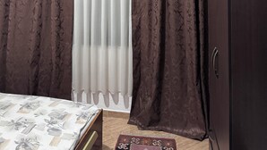 A bedroom with a bed, a wardrobe, and curtains. - VILA CANO (Durrës)