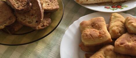 A table with plates of food including bread and pastries.