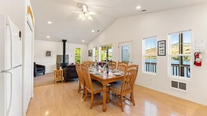 A spacious dining area with a wooden table set for six, surrounded by wooden chairs. - Private Lakefront Retreat - Hot Tub - Dock - EV Charger - Near Lake Chelan (Chelan County)