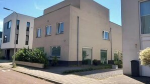 Een modern gebouw met een plat dak, rechthoekige ramen en een strak, minimalistisch ontwerp.