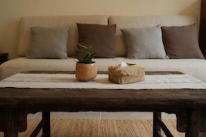 A rustic wooden table with a potted plant and a tissue box on a woven placemat. - Lexinghua Juzhusu (Taizhou Tiantai Guoqing Scenic Area Branch) (Tiantai County)