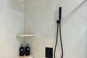 A modern bathroom with a shower, a shelf, and two bottles of soap. - Lexinghua Juzhusu (Taizhou Tiantai Guoqing Scenic Area Branch) (Tiantai County)