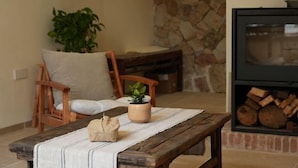 Un coin salon accueillant avec un banc en bois, un fauteuil rembourré et une plante en pot.