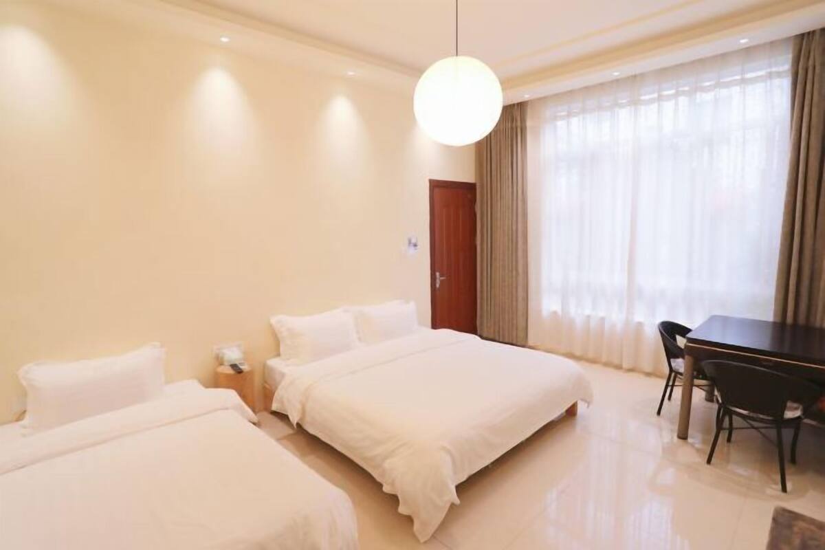 Een hotelkamer met twee bedden, een bureau en een stoel.