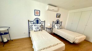 A room with two beds, a small table, a chair, and a wardrobe. - Akonxego&C.ia. Mourão - Capital of Alqueva. ☀️. (Mourão)