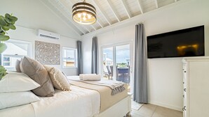 Un dormitorio con cama, televisión, ventana y vista al exterior.