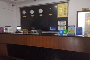 A reception desk with clocks, a directory, and informational signs.