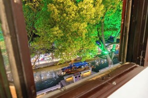 A view of a river with boats and trees illuminated by green lights. - Duyun Yuxiang Inn (Kunshan)