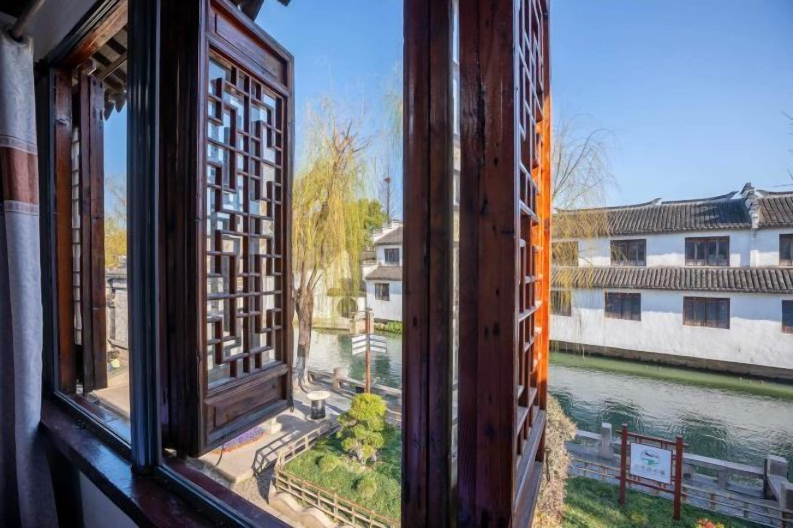 A traditional building with a view of a river and a white wall with windows.