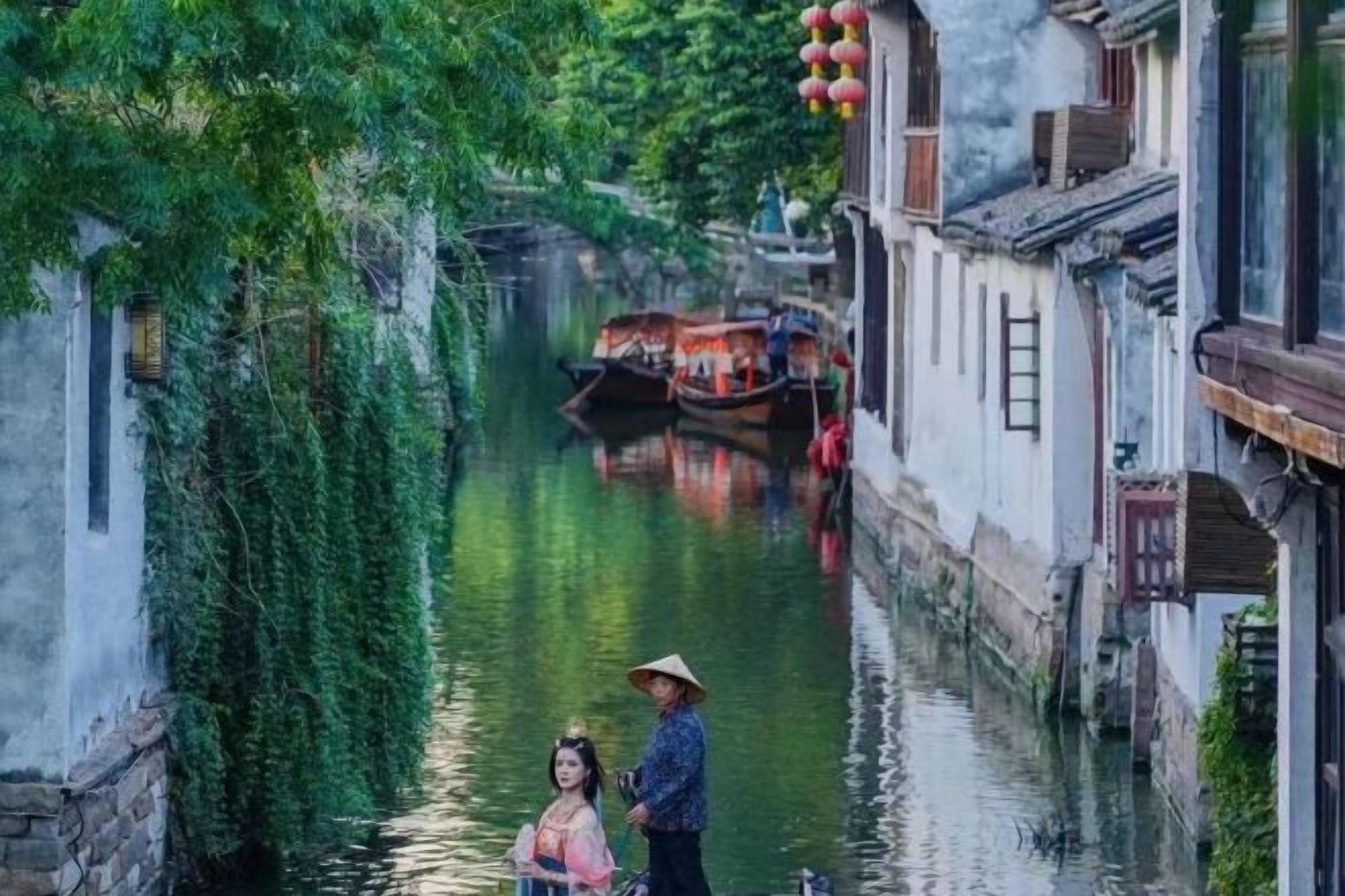 A narrow waterway flanked by traditional buildings, a boat, and two individuals.