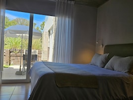 A bedroom with a bed, a window, and a view of the outdoors.