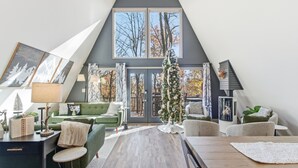 En moderne stue i loftstil med et stort vindue, en pejs og et juletræ.