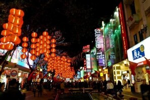 A busy street at night with illuminated signs and decorations. - Jinyuan Projection Apartment (Beijing Road Pedestrian Street Store) (Guangzhou)